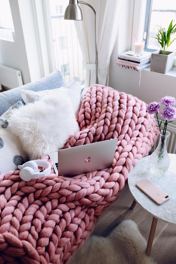 a pink chunky knit blanket is great for a girlish space, add a couple of fluffy pillows and voila