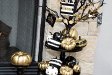 08 a stand with black, gold and white pumpkins with stripes and polka dots looks cute and glam