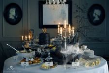 11 a glam and decadent Halloween dessert table with vintage candle holders and a black cake
