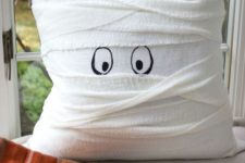 11 a pillow wrapped with white cheesecloth and with painted eyes as a cute mummy pillow