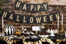 12 a stylish black and gold Halloween dessert table, lots of desserts and a gold leaf garland