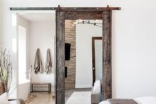 13 a reclaimed wood and mirror sliding door and some faux fur rugs and covers add rustic coziness