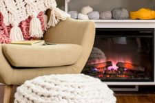 13 a white chunky knit ottoman or footrest is a cozy piece to sit on next to the fireplace