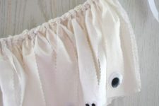 13 a white fabric garland with googly eyes for scary and chic decor