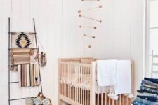 13 a wooden crib, a wicker basket and a wooden mobile add a cozy rustic feel to the space