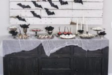 14 a vintage sideboard covered with cheesecloth and a pallet sign with bats for simple Halloween decor