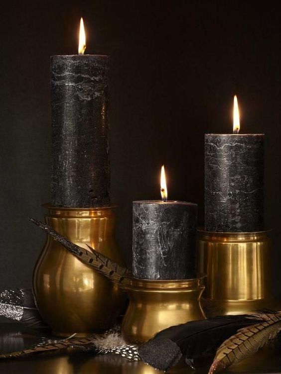 black candle in gold candle holders for elegant and sophisticated Halloween decor