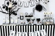 15 black and white dessert table with a faux tree and an owl, a spider and a banner