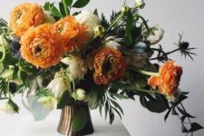 04 a stylish Thanksgiving arrangement with orange, white blooms, greenery and thistles