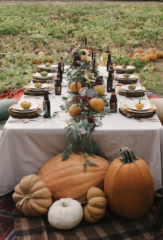 a leafy table runner with real pumpkins for a cozy table setting