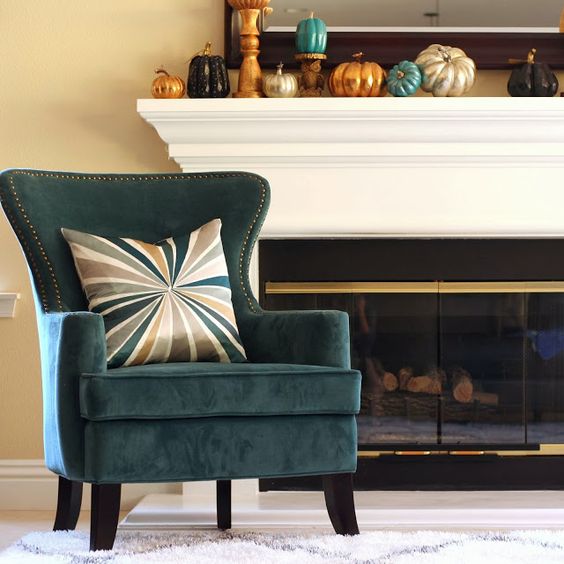 a modern mantel with an arrangement of colorful faux pumpkins on stands
