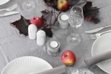 07 stylish, minimalist autumnal table setting with apples, candles and dark leaves looks wow