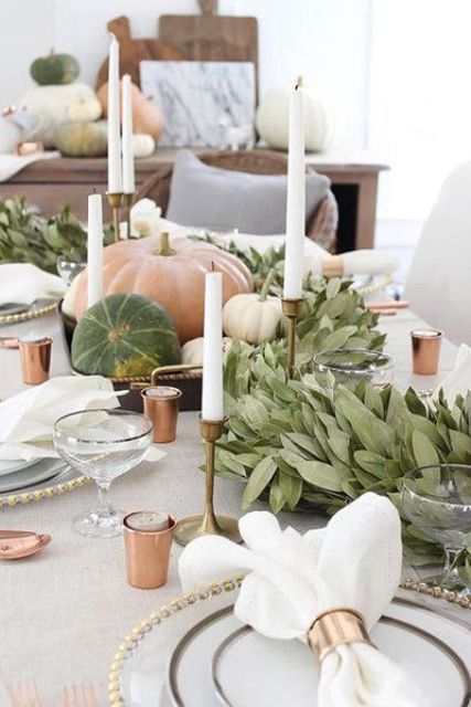 a lush leaf table runner with candles and pumpkins is a perfect idea to hint on the harvest holiday