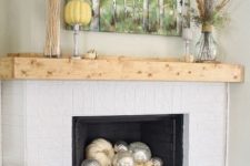 09 a chic mantel with wheat, feathers and pumpkins and some pumpkins inside the fireplace