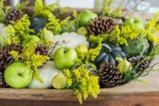 10 a bowl with green apples, pinecones, white and dark green pumpkins and greenery