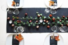 11 a chic fall tablescape with a black table runner, acorns, foliage and fall leaves