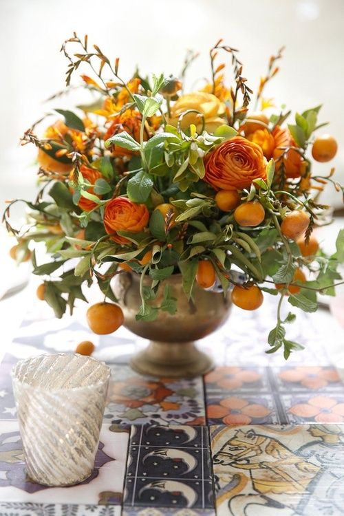 a lush centerpiece with citrus and orange blooms for a cool Thanksgiving table