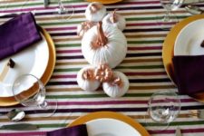 13 a colorful tablescape with a striped tablecloth, purple napkins, white and gold pumpkins