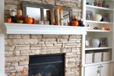 13 a mantel with faux leaves, birch branches, candles and pumpkins, a mirror to highlight them