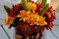 13 orange and burgundy blooms, nuts inside the vase for a fall look
