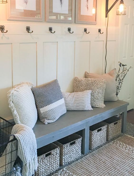 a wooden bench with wicker baskets as drawers and a just rug for coziness