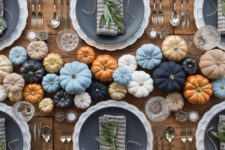 15 a modern and bold Thanksgiving table setting with colorful pumpkins in the center, matte black plates and greenery