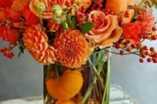 15 orange roses, berries, dahlias and orange pumpkins inside the vase for a monochromatic look