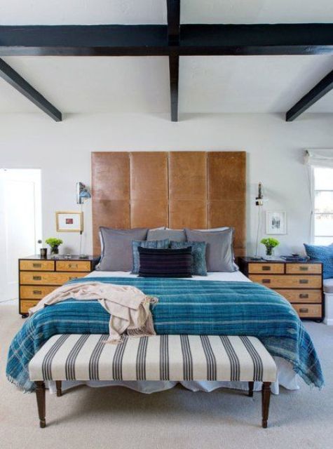 an eclectic space with a tall brown leather headboard for a textural touch