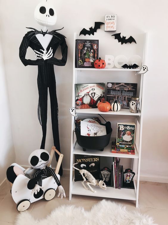 Nightmare Before Christmas Halloween decor with a shelf with bats, pumpkins, books and a skeleton, a Jack Skellington prop and a kid one