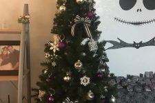 a Christmas tree with purple and gold ornaments and bows plus Jack Skellington decorations for more chic