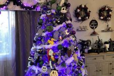 a Nightmare Before Christmas tree with striped ribbons, purple lights and themed ornaments and a swirl on top