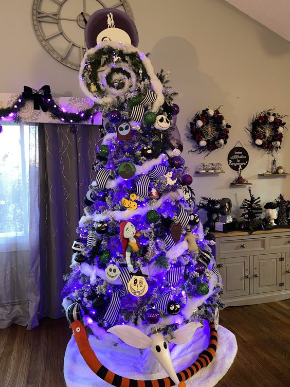 a Nightmare Before Christmas tree with striped ribbons, purple lights and themed ornaments and a swirl on top