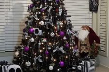 a black Halloween tree decorated with lights, Jack Skellington ornaments, purple ones and some striped bows