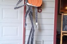 a cool Jack Skellington prop with a pumpkin made of cardboard is a simple decoration that can be DIYed