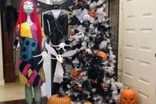 a white Christmas tree decorated with Halloween pumpkins, black branches and eyeballs, bats and other stuff can be a fit for Halloween, too
