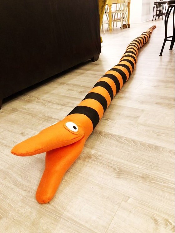 an orange and black striped Halloween decoration - a Nightmare Before Christmas tree eating snake
