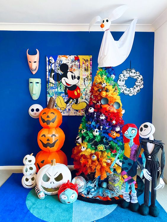 colorful Nightmare Before Christmas decor with a rainbow tree with ornaments, bright props and pumpkins is pure fun