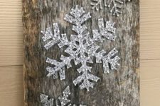 03 a reclaimed wood piece with string art silver snowflakes looks very cool