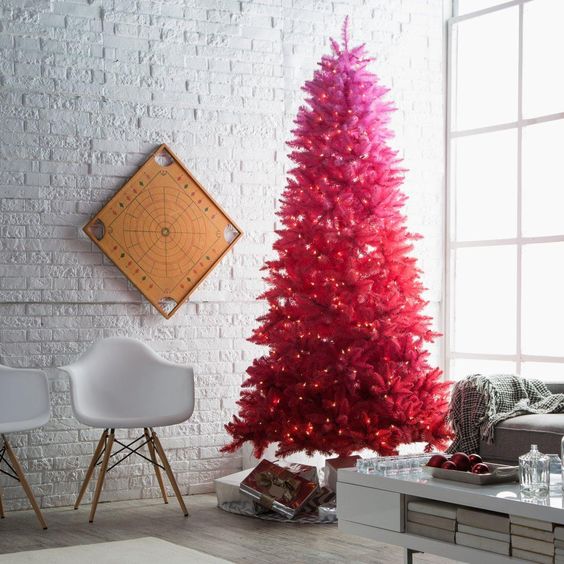 an ombre neon pink to red Christmas tree with lights doesn't need any ornaments