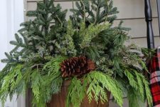 04 a bushel basket with evergreens and a large pinecone for decorating outdoors