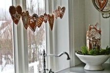 05 glazed heart-shaped gingerbread cookies hanging on a branch on the window