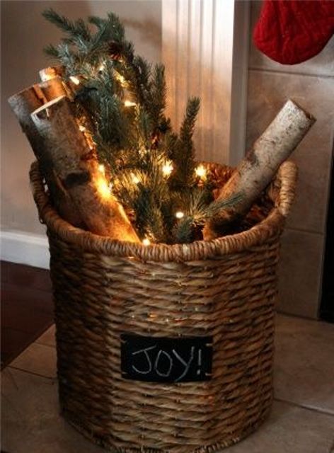 a basket with a chalkboard piece, evergreens, branches and LED lights for a Christmas feel