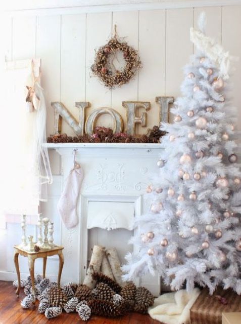 a white tree with champagne and grey ornaments that make ti bolder