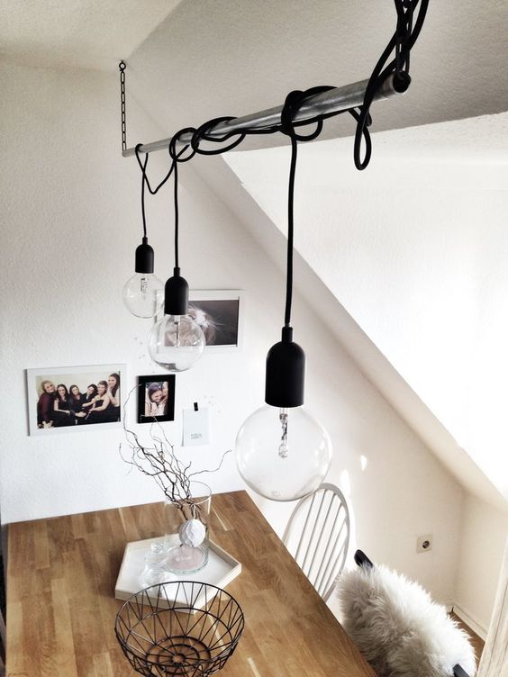 a hanging pendant metal tube and bulbs hanging on cords from it for a Scandinavian space
