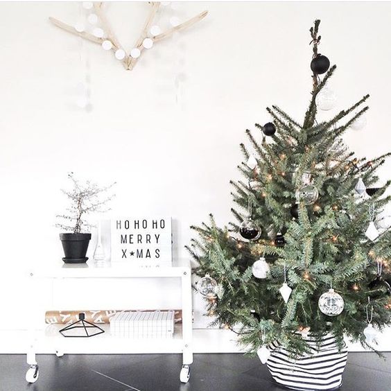 a chic tree with sheer and black and white ornaments and a striped base