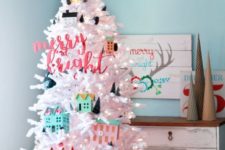 09 a white tree decorated with colorful houses and mini trees for a fun touch in a kid’s space