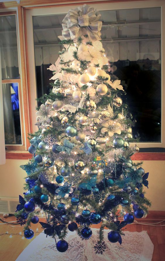 a Christmas tree with ombre decor from white to electric blue looks very bold