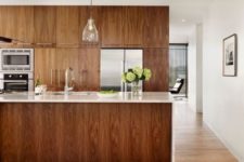 12 rich-colored sleek wooden cabinets with white marble countertops for a refined look