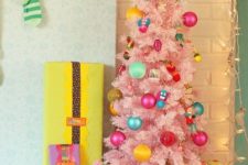 13 a cute pastel pink Christmas tree with colorful ornaments for a child’s space