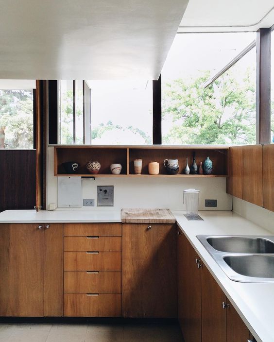 sleek wooden cabinets and white countertops and wooden open cupboards over the tops